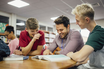 Sozialpädagoge unterstützt Jugendliche bei den Hausaufgaben