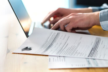 Studieninteressent schreibt seine Bewerbung für das soziale Arbeit Studium am Laptop.