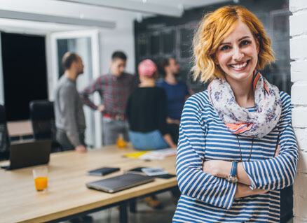 Duale Studentin steht lächelnd im Büro