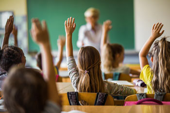 Kinder in einer Schulklasse melden sich