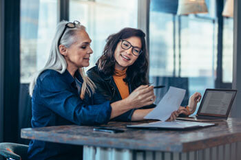 Zwei Sozialarbeiterinnen besprechen ein Projekt.