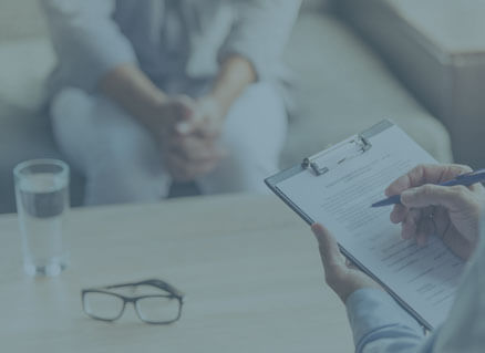 Ein Sozialpsychologe spricht mit einer Patientin und macht sich Notizen.